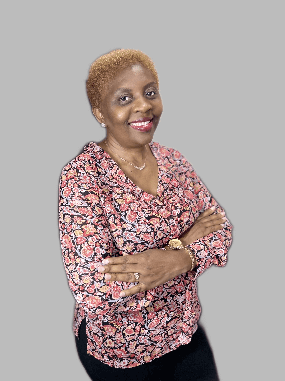 Smiling woman in floral blouse, arms crossed medical care